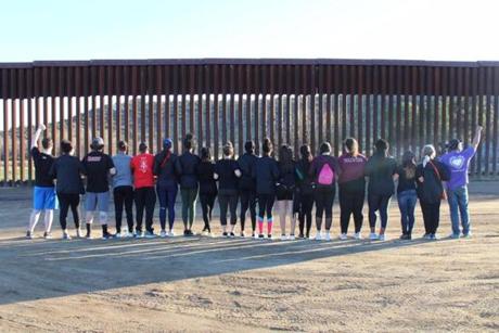 Regis college students stood facing the Mexican border in Southern California.
