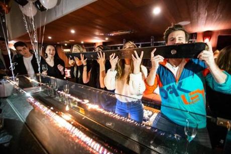 01/04/2019 BOSTON, MA A group of friends shares a shot ski in the courtyard at Publico in Boston. (Aram Boghosian for The Boston Globe)
