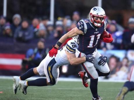 Foxborough, MA - 1/13/2018 - Julian Edelman tackled by Nick Dzubnar during the third quarter. The New England Patriots host the Los Angeles Chargers during the divisional playoff game at Gillette Stadium. Stan Grossfeld/Globe Staff
