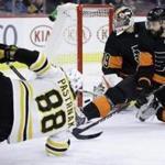 Philadelphia Flyers' Carter Hart, center, and Radko Gudas, right, cannot stop a goal by Boston Bruins' David Pastrnak during the first period of an NHL hockey game, Wednesday, Jan. 16, 2019, in Philadelphia. (AP Photo/Matt Slocum)
