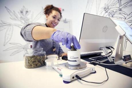 Andrea Lawrence measures out an order for a medical marijuana patient trying to beat the lines at Theory Wellness in Great Barrington, Mass., before Friday's opening day for adult-use recreational marijuana on Thursday, Jan. 10, 2019. (Stephanie Zollshan/The Berkshire Eagle via AP)
