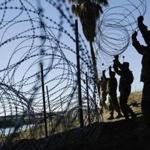 FILE - In this Nov. 16, 2018, file photo, members of the U.S. military install multiple tiers of concertina wire along the banks of the Rio Grande near the Juarez-Lincoln Bridge at the U.S.-Mexico border in Laredo, Texas. Acting Defense Secretary Pat Shanahan says the U.S. will be sending 