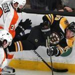 Boston 01/31/19 Bruins vs Flyers- Bruins Brad Marchand is checked into the boards in the 2nd period by Flyers Radko Gudas as he passes the puck. Photo by John Tlumacki/Globe Staff(sports)
