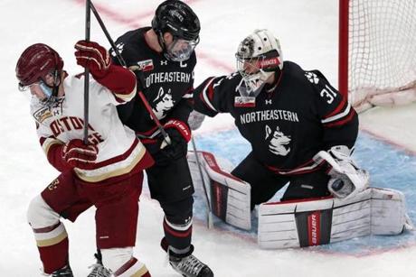 2-11-19 Boston, MA: Northeastern goalie Cayden Primeau (right) makes a second period glove save with BC's Julius Mattila (left) and teammate Eric Williams (center) in front of him. Northeastern University met Boston College in the Beanpot\Championship Game at the TD Garden. (Jim Davis /Globe Staff)
