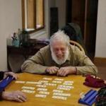 Dover-Foxcroft, ME, 01/16/2019 -- David Migneault, of Garland, (C) laughs as he plays Rummikub with his wife, Peggy, (R) and friend Alden Bent, of Dover-Foxcroft downstairs in Central Hall following a weekly community lunch upstairs at The Commons. Dover-Foxcroft, like nearly all Maine towns, is aging rapidly. But, unlike many other communities, they're planning aggressively for a silver-haired future. (Jessica Rinaldi/Globe Staff) Topic: 20maine Reporter: 