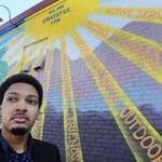 Jordan Thompson, 20, is one of 22 men from around the country picked to participate in Barack Obama's My Brother's Keeper summit in Oakland, Calif. He poses in Nashua, N.H., next to a mural near City Hall created by PositiveStreetArt.org. 