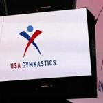 FILE - In this Feb. 26, 2014, file photo, the USA Gymnastics logo is displayed at AT&T Stadium during an news conference announcing in Arlington, Texas. USA Gymnastics has filed a Chapter 11 bankruptcy petition on Wednesday, Dec. 5, 2018, as it attempts to reach settlements in the dozens of sex-abuse lawsuits it faces and to forestall its potential demise at the hands of the U.S. Olympic Committee. (Ron Jenkins/Star-Telegram via AP)