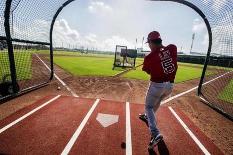 Fort Myers, Fl- Feb 18, 2019-Stan Grossfeld/Globe Staff--Red Sox Spring Training at JetBlue Park. Postcard from Spring Training 2 of 3 Just for fun I asked the Red Sox if I could get behind the hitter in the batting cage. Surprisingly, they said yes. Red Sox infielder Tzu-Wei Lin was at bat. I crouched low behind him with a camera but not a glove. Uh, maybe I didnÕt think this through. Lin, from Taiwan looked at me like I was crazy. ÒDo not miss,Ó I said. The cage forms a picture frame around the hitter and isolates him from the fans. ThereÕs a matt covering the batters box and itÕs spongy and retains a good grip. Assistant hitting coach Andy Barkett delivers a medium speed meatball right down the middle. For a split second, Lin stands motionless, the beautiful white shiny ball with the spinning red seams heads straight for my um, midsection. But then Lin uncoils and crushes a towering shot to left center. I am relieved. Lin later said he felt much pressure. ÒWhen you walked in there I said ÔOh my God,Õ really youÕre going to take a picture from behind home plate? I was scared and Andy was too. If I swing and miss you are going to get hurt. So I tried to just hit the ball.Ó
