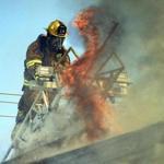 A Dover, N.H., firefighter attacked flames during a four-alarm fire Friday in Berwick, Maine.