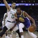 Golden State Warriors' Kevin Durant, right, drives the ball against Boston Celtics' Jayson Tatum (0) during the first half of an NBA basketball game Tuesday, March 5, 2019, in Oakland, Calif. (AP Photo/Ben Margot)