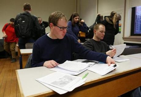 Johan Rijk (left) sat with his brother, Matt, who took notes for him in a class at Framingham State University last month. Johan suffered a stroke in 2010, when he was a junior, that paralyzed him.
