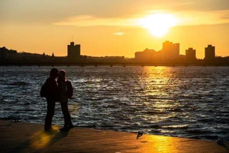 03/11/2019 BOSTON, MA Hamit Sahin (cq) (left) kisses his wife Laura Chambre (cq) of Boston, during the last hour of sunlight on the Charles River Esplanade in Boston. (Aram Boghosian for The Boston Globe)

