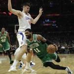 Boston Celtics' Kyrie Irving, bottom, slips as he drives past Los Angeles Clippers' Ivica Zubac, of Croatia, during the second half of an NBA basketball game, Monday, March 11, 2019, in Los Angeles. The Clippers won 140-115. (AP Photo/Jae C. Hong)