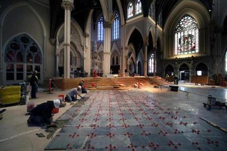 As part of the renovation of the Cathedral of the Holy Cross in Boston, workmen are installing the new marble floors, original pews, exterior lighting, and video and audio technologies.

