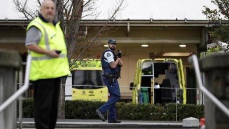Law enforcement members stand guard at Christchurch Hospital, which is under lockdown, after a mass shootings at two mosques in Christchurch, New Zealand, Saturday, March 16, 2019. (AP Photo/Mark Baker)
