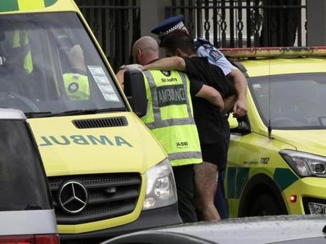 First responders helped a wounded man from outside a mosque in Christchurch, New Zealand, on Friday.
