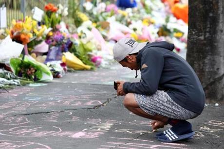 Locals in Dunedin, New Zealand lay flowers and condolences in tribute to those killed and injured.
