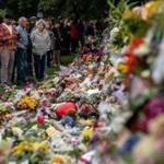 CHRISTCHURCH, NEW ZEALAND - MARCH 17: People pause next to flowers and tributes by the wall of the Botanic Gardens on March 17, 2019 in Christchurch, New Zealand. 50 people are confirmed dead, with 36 injured still in hospital following shooting attacks on two mosques in Christchurch on Friday, 15 March. 41 of the victims were killed at Al Noor mosque on Deans Avenue and seven died at Linwood mosque. Another victim died later in Christchurch hospital. A 28-year-old Australian-born man, Brenton Tarrant, appeared in Christchurch District Court on Saturday charged with murder. The attack is the worst mass shooting in New Zealand's history. (Photo by Carl Court/Getty Images)