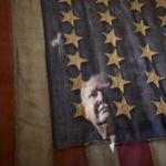 Lee Humiston of Maine Military Museum was reflected in the glass of the framed flag.