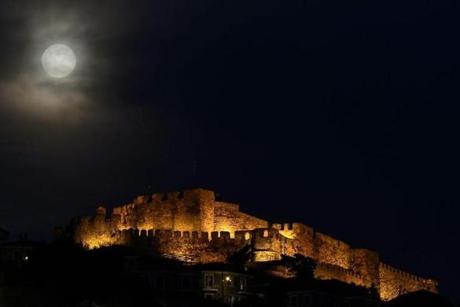 A full moon rises next to the ancient castle of Mithymna Molyvos on the Greek island of Lesbos on March 20, 2019. (Photo by ARIS MESSINIS / AFP)ARIS MESSINIS/AFP/Getty Images
