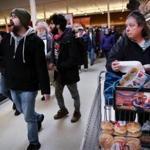 A shopper watched as Jim Carvalho (left) marched with fellow members of the United Food and Commercial Workers Union and their supporters during a rally Sunday at the Stop & Shop in Somerville.