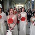 Unchained At Last members marched down the hallway of the State House towards Governor Charlie Baker's office in protest on Wednesday. They urged legislators to end Massachusetts child marriage. 