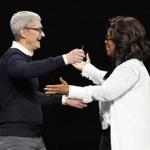 Apple CEO Tim Cook and Oprah Winfrey prepare to embrace at the Steve Jobs Theater during an event to announce new products Monday in Cupertino, Calif.
