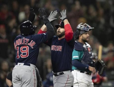 Boston Red Sox's Mitch Moreland, center, is congratulated by Jackie Bradley Jr., after hitting a three-run home run off of Seattle Mariners Hunter Strickland during the ninth inning of a baseball game Friday, March 29, 2019, in Seattle. (AP Photo/Stephen Brashear)
