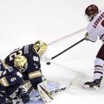 Massachusetts forward John Leonard (9) fakes Notre Dame goaltender Cale Morris (32) as he sets up his goal during the second period of an NCAA Division I men's ice hockey regional game in Manchester, N.H., Saturday, March 30, 2019. (AP Photo/Charles Krupa)