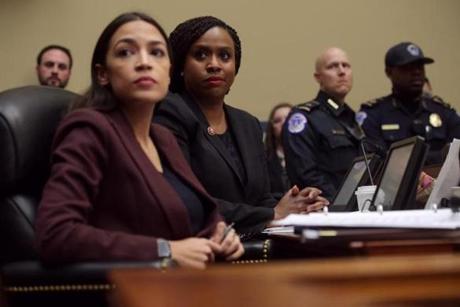 WASHINGTON, DC - FEBRUARY 27: Rep. Ayanna Pressley (D-MA) (R) and Rep. Alexandria Ocasio-Cortez (D-NY) listen to Michael Cohen, former attorney and fixer for President Donald Trump as he testifies before the House Oversight Committee on Capitol Hill February 27, 2019 in Washington, DC. Last year Cohen was sentenced to three years in prison and ordered to pay a $50,000 fine for tax evasion, making false statements to a financial institution, unlawful excessive campaign contributions and lying to Congress as part of special counsel Robert Mueller's investigation into Russian meddling in the 2016 presidential elections. (Photo by Alex Wong/Getty Images)
