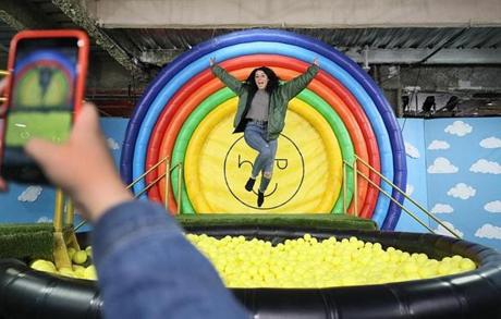 Boston, MA., 04/02/2019, Danae Pieroni, cq, gets a photo of herself jumping into a ball pit at The Happy Place---- a roving installation of quasi-art for the Instagram set which took over a former Marshall's on Boylston Street, and influencers and others toured the exhibit and had their photos taken to post with the Happy Place hashtag. Globe staff/Suzanne Kreiter
