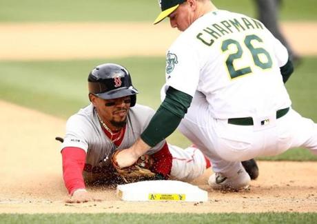 OAKLAND, CALIFORNIA - APRIL 04: Mookie Betts #50 of the Boston Red Sox is tagged out by Matt Chapman #26 of the Oakland Athletics at third base in the ninth inning at Oakland-Alameda County Coliseum on April 04, 2019 in Oakland, California. (Photo by Ezra Shaw/Getty Images)
