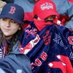 Fans huddled together during the 2018 Red Sox home opener at Fenway Park. This year?s game will be played in similarly chilly temperatures with the chance of rain showers toward the late afternoon.