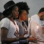 India Haye (left) and Jheneire Loreus held candles during an event celebrating the life and spirit of Nipsey Hussle with a candelight vigil, music, and a panel discussion at Black Market Dudley in Roxbury last week.