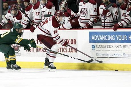 FILE - In this Saturday, Jan. 12, 2019 file photo, UMass Amherst defenseman Cale Makar (16) reaches for the puck with Vermont forward Vlad Dzhioshvili (10) close behind during a NCAA hockey game in Amherst, Mass. Defenseman Cale Makar cited loyalty in sticking to his commitment to play at Massachusetts despite a coaching change. Two years later, Makar is a Hobey Baker finalist and has the Minutemen (30-9) preparing to make their first Frozen Four appearance. UMass will face Denver, while Providence is playing Minnesota Duluth in the semifinals on Thursday, April 11, 2019.(AP Photo/Scott Eisen, File)
