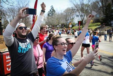 Spectators cheer for a runner along Commonwealth Avenue. 
