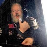 Julian Assange gestured as he arrived at Westminster Magistrates' Court in London, after the WikiLeaks founder was arrested by officers from the Metropolitan Police and taken into custody Thursday.