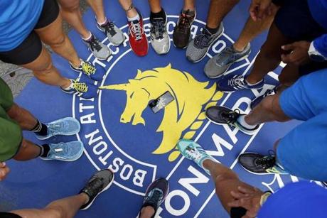 Boston, MA, 04/14/2019 -- Members of the Florida Forerunners place their feet in a circle on the Finish Line as they pose for a photo. The St. Petersburg running group will take on the Boston Marathon tomorrow. (Jessica Rinaldi/Globe Staff) Topic: 15marathoncolor Reporter: 
