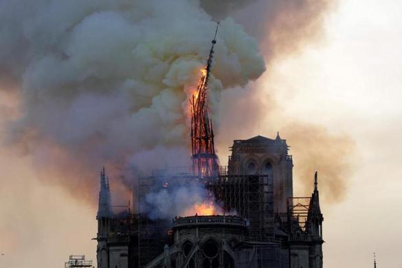 The steeple of the landmark Notre-Dame Cathedral collapses as the cathedral is engulfed in flames in central Paris on April 15, 2019. - A huge fire swept through the roof of the famed Notre-Dame Cathedral in central Paris on April 15, 2019, sending flames and huge clouds of grey smoke billowing into the sky. The flames and smoke plumed from the spire and roof of the gothic cathedral, visited by millions of people a year. A spokesman for the cathedral told AFP that the wooden structure supporting the roof was being gutted by the blaze. (Photo by Geoffroy VAN DER HASSELT / AFP)GEOFFROY VAN DER HASSELT/AFP/Getty Images