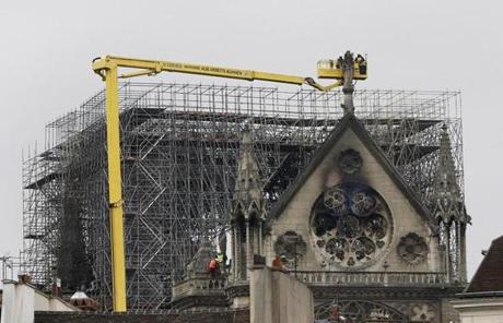 Cathedral SLIDER A crane lifts experts as they inspect the damaged Notre Dame cathedral after the fire in Paris, Tuesday, April 16, 2019. Experts are assessing the blackened shell of Paris' iconic Notre Dame cathedral to establish next steps to save what remains after a devastating fire destroyed much of the almost 900-year-old building. With the fire that broke out Monday evening and quickly consumed the cathedral now under control, attention is turning to ensuring the structural integrity of the remaining building. (AP Photo/Kamil Zihnioglu)
