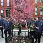 Boston firefighters gathered around a tree that was dedicated at the fire scene in memory of two Boston firefighters.