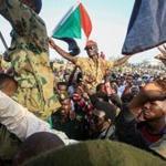 Sudanese protesters shouted slogans as they carried soldiers during a rally outside the army complex in Sudan's capital Khartoum on Thursday.