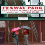 06/01/15: Boston, MA: Monday night's scheduled Red Sox game vs. the Minnesota Twins at Fenway Park was rained out. It will be made up on Wednesday as part of separate admission day-night doubleheader. Late Monday afternoon two people stood under umbrellas outside of the Gate D stairs entrance on Yawkey Way. (Globe Staff Photo/Jim Davis) section: sports topic: Red Sox-Twins (1)