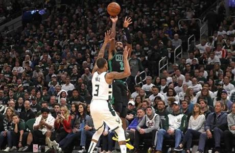 Milwaukee, WI - 4/28/2019 - (4th quarter) Boston Celtics guard Kyrie Irving (11) drains a three over Milwaukee Bucks guard George Hill (3) in the fourth quarter. The Milwaukee Bucks host the Boston Celtics in Game 1 of the Eastern Conference NBA Semi-Finals at Fiserv Forum. - (Barry Chin/Globe Staff), Section: Sports, Reporter: Adam Himmelsbach, Topic: 29Celtics-Bucks, LOID: 8.5.1108988016.
