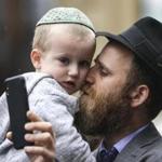 Mendy Uminer of Chestnut Hill embraces his son Berel, 3, during a vigil held near the New England Holocaust Memorial on Sunday in support of victims of an attack on a synagogue near San Diego.