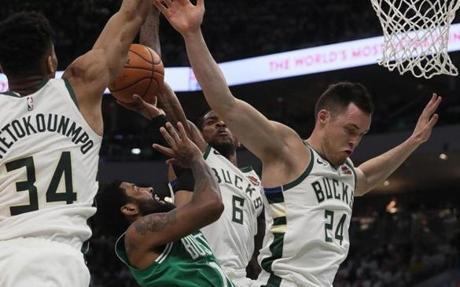 Milwaukee, WI - 4/30/2019 - (4th quarter) Kyrie Irving is stuffed by Milwaukee Bucks guard Eric Bledsoe (6) and Milwaukee Bucks forward Giannis Antetokounmpo (34) as he tries to drive for a layup during the fourth quarter. Irving had one of his worst games as a Celtic, finishing with 9 points on 4-of-18 shooting, along with 4 assists and 3 turnovers.The Milwaukee Bucks host the Boston Celtics in Game 2 of the Eastern Conference NBA Semi-Finals at Fiserv Forum. - (Barry Chin/Globe Staff), Section: Sports, Reporter: Adam Himmelsbach, Topic: 01Celtics-Bucks, LOID: 8.5.1138982852.
